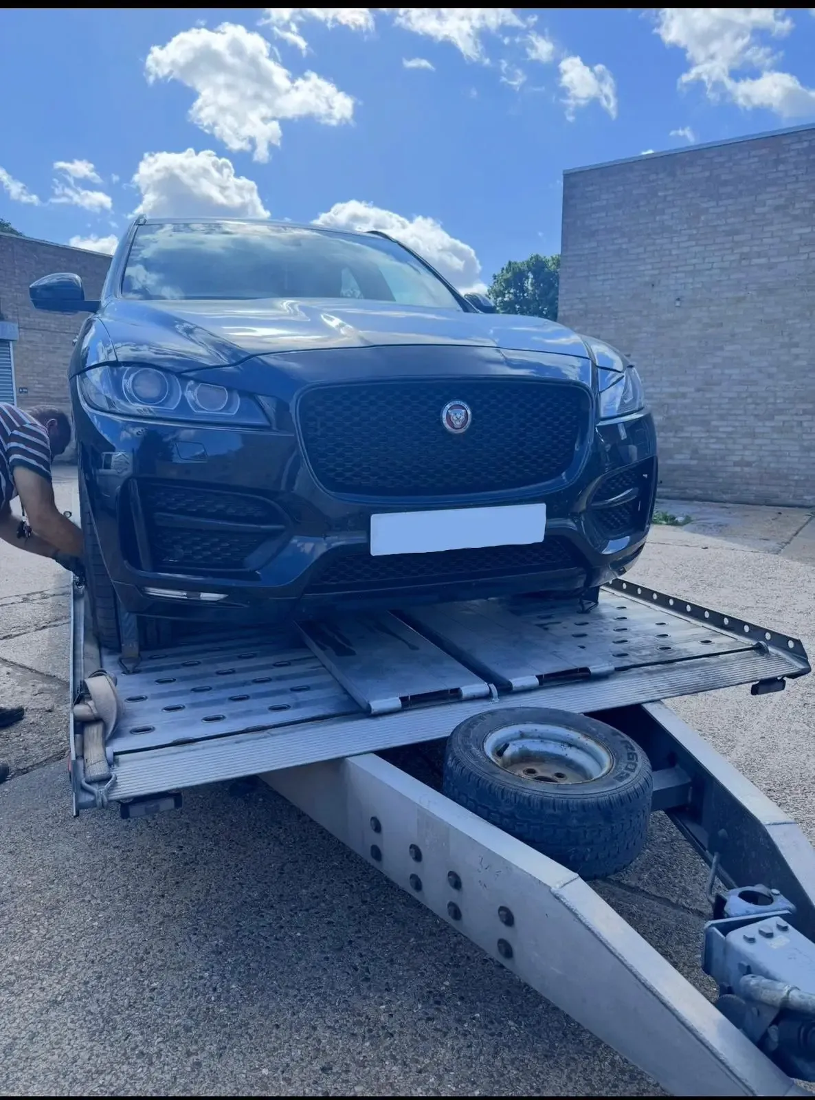 Blue Jaguar F-Pace on flatbed transporter being collected for engine service at JLR Engine Specialists in Billericay – nationwide fitting available