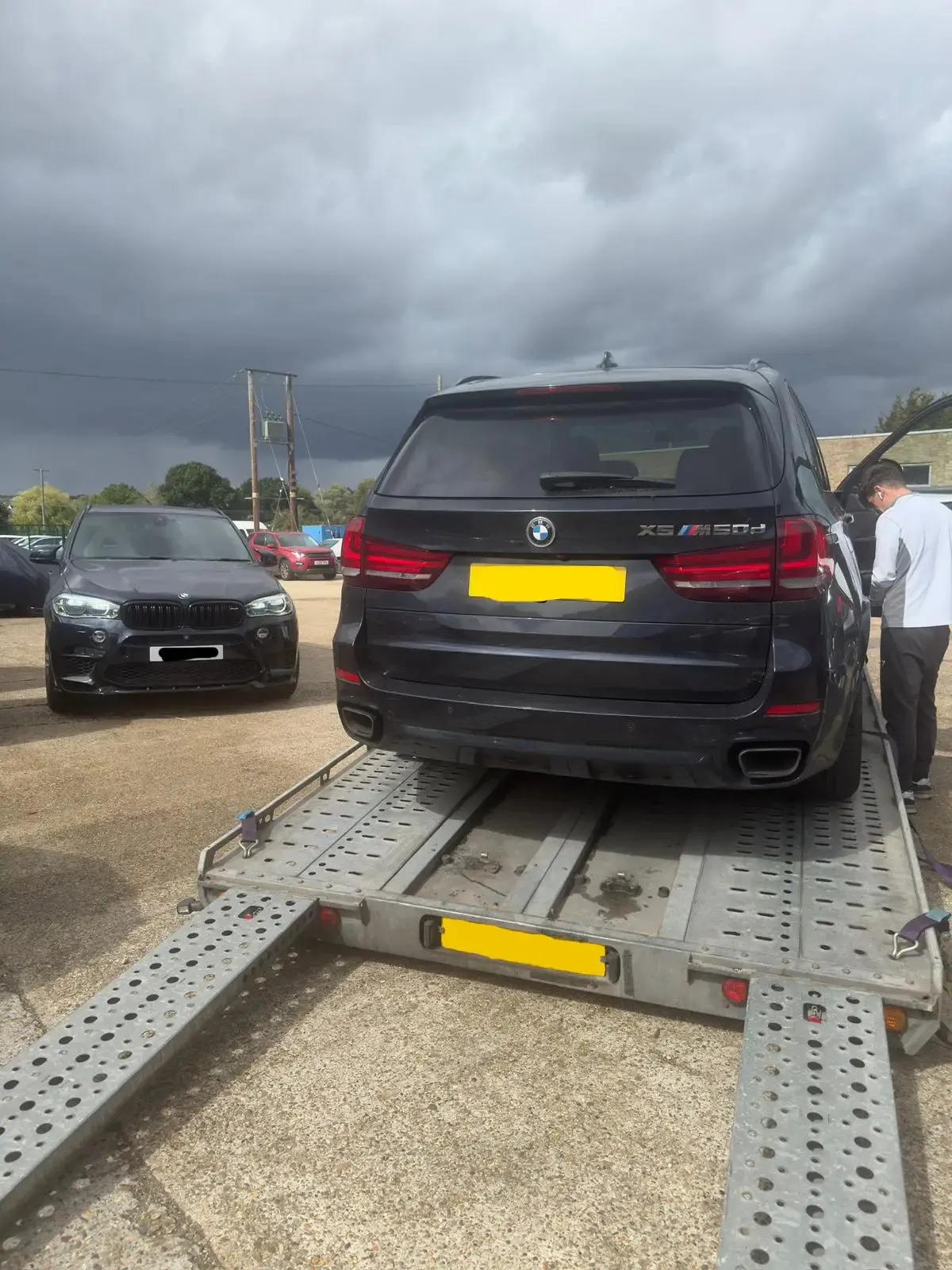 Black BMW X5 M50d on flatbed transporter being collected for engine repair – JLR Engine Specialists offers nationwide fitting with 12-month unlimited mileage warranty