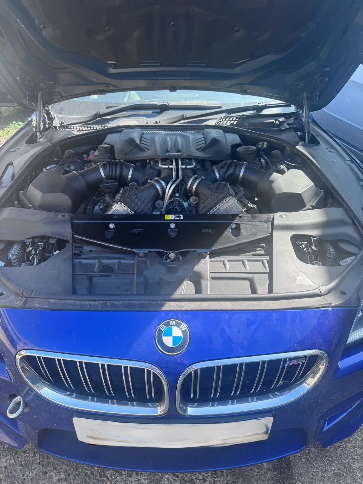 Close-up of BMW M5 engine bay with V8 supercharged engine exposed – serviced by JLR Engine Specialists for high-performance BMW models
