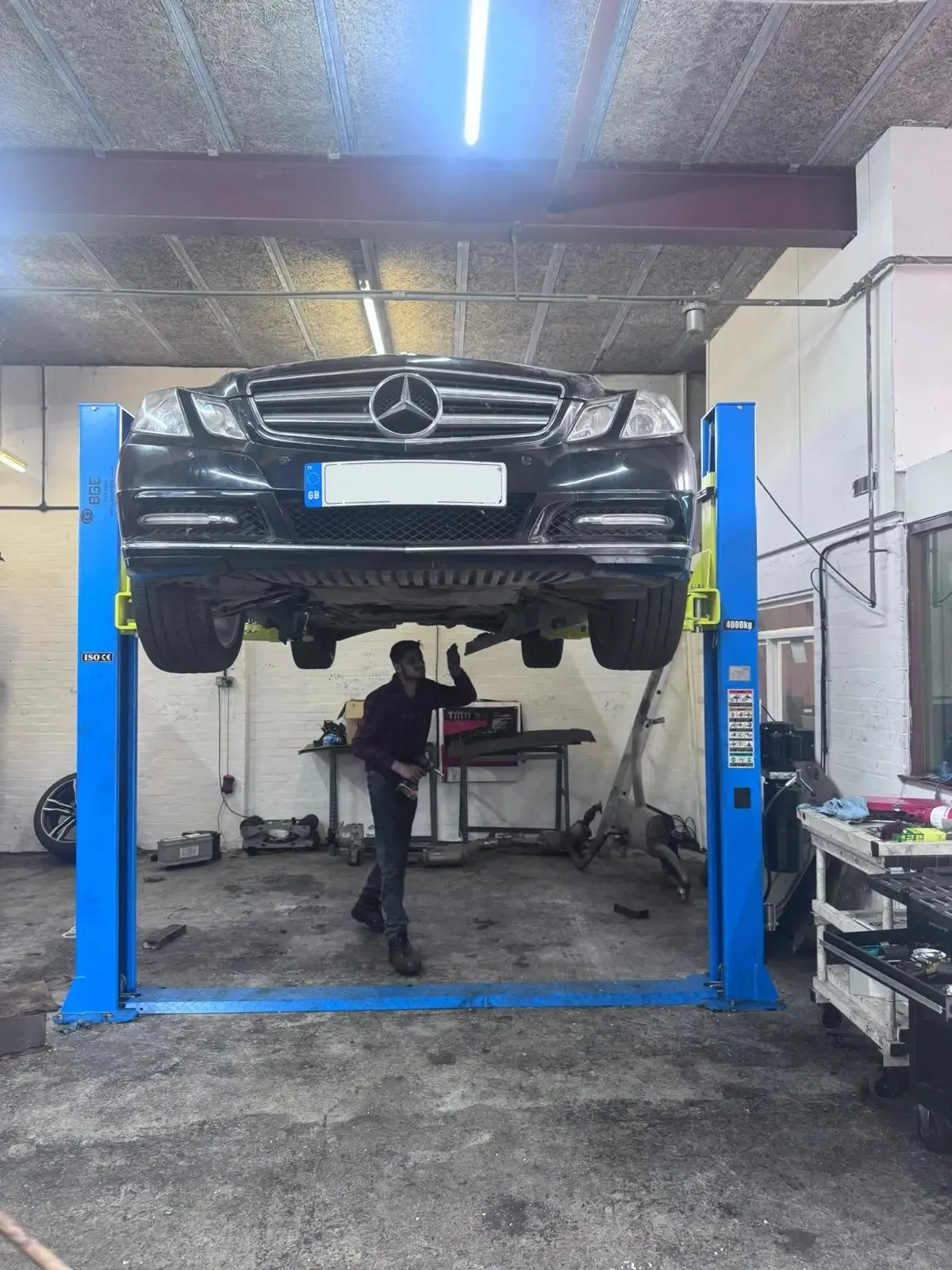 Mercedes-Benz vehicle on lift for engine service at JLR Engine Specialists – IMI-certified technicians working on luxury vehicles including BMW & Mercedes