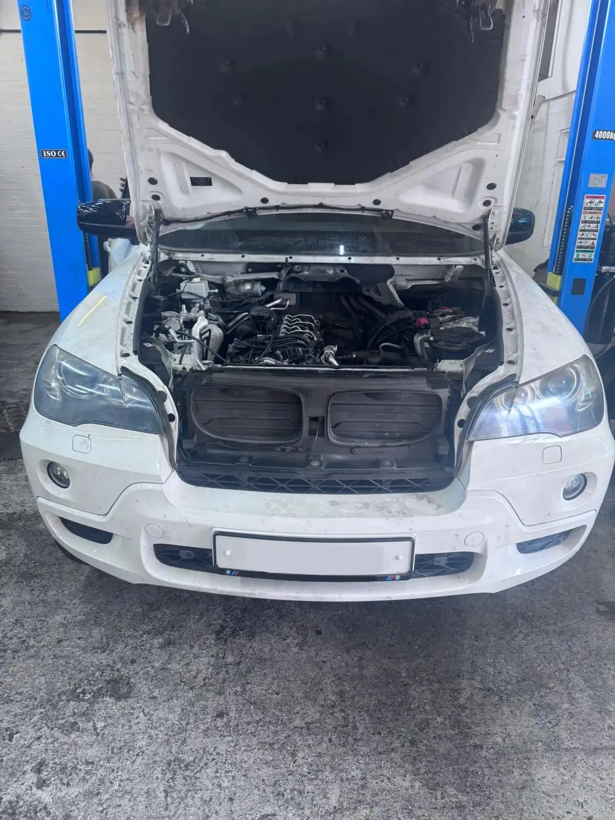 White BMW X5 with engine bay exposed for rebuild at JLR Engine Specialists – IMI-certified technicians servicing BMW, Jaguar & Land Rover vehicles