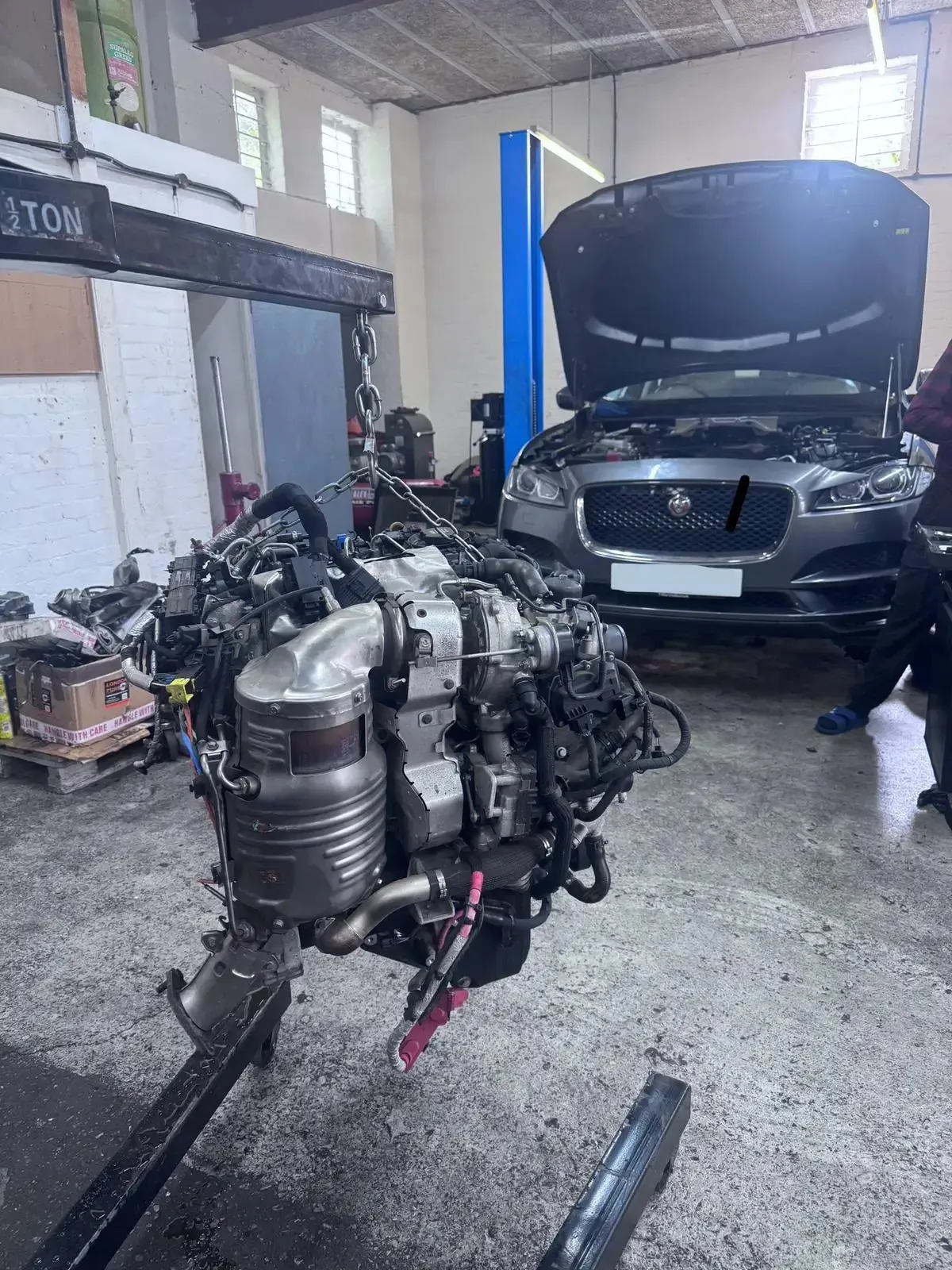 Jaguar XF engine suspended on hoist for rebuild at JLR Engine Specialists workshop in Billericay – IMI-certified technicians using OEM-spec parts