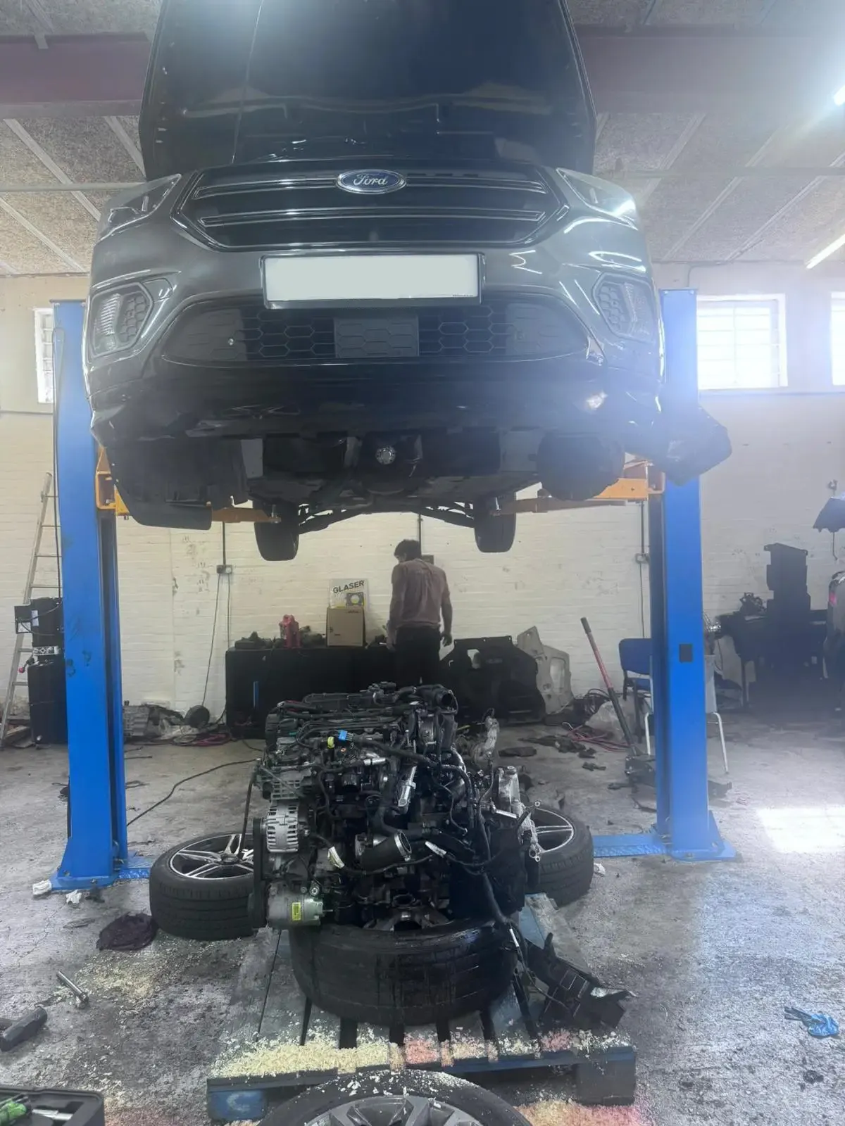 Ford Kuga on lift with engine removed for replacement at JLR Engine Specialists – servicing a range of vehicles including Ford, BMW & Jaguar Land Rover