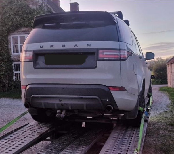 Silver Range Rover Urban on flatbed transporter being collected for engine repair – JLR Engine Specialists offers nationwide fitting with 12-month warranty