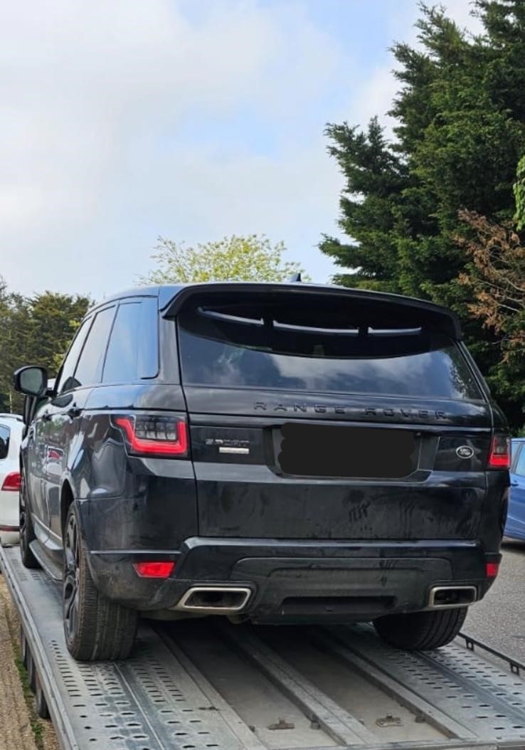 Black Range Rover Sport on flatbed transporter being collected for engine repair – JLR Engine Specialists offers nationwide fitting with 12-month unlimited mileage warranty